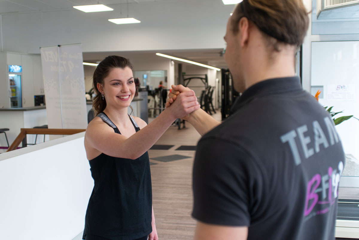 Trainer begrüßt eine Sportlerin im B-FiT Studio Roßtal